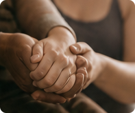 Two people holding hands in comfort and support.